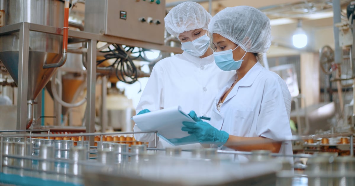 Quality control officer inspecting a food production line where product is being filled and packed